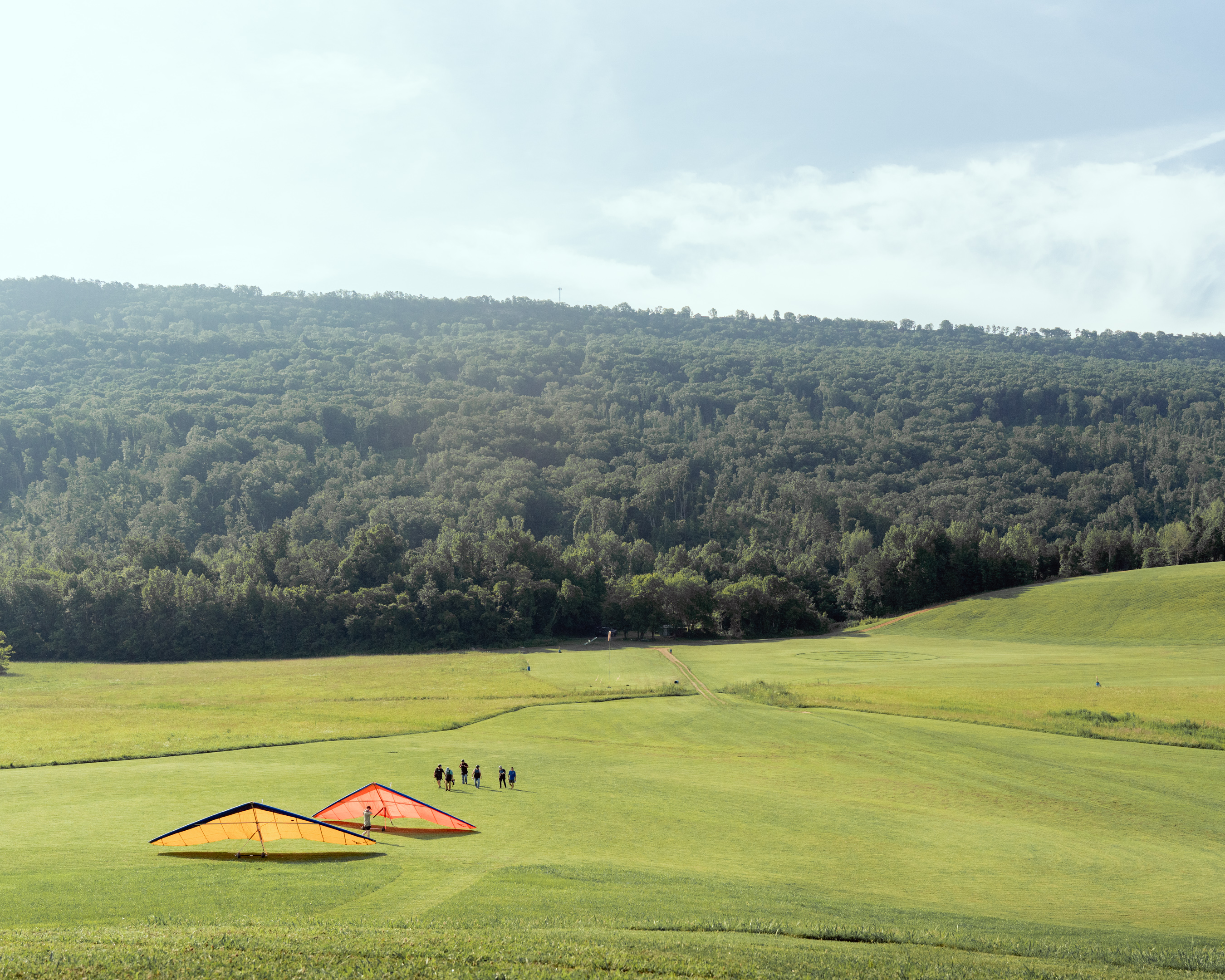 Hang gliders resting in a field after a cross-country landing
