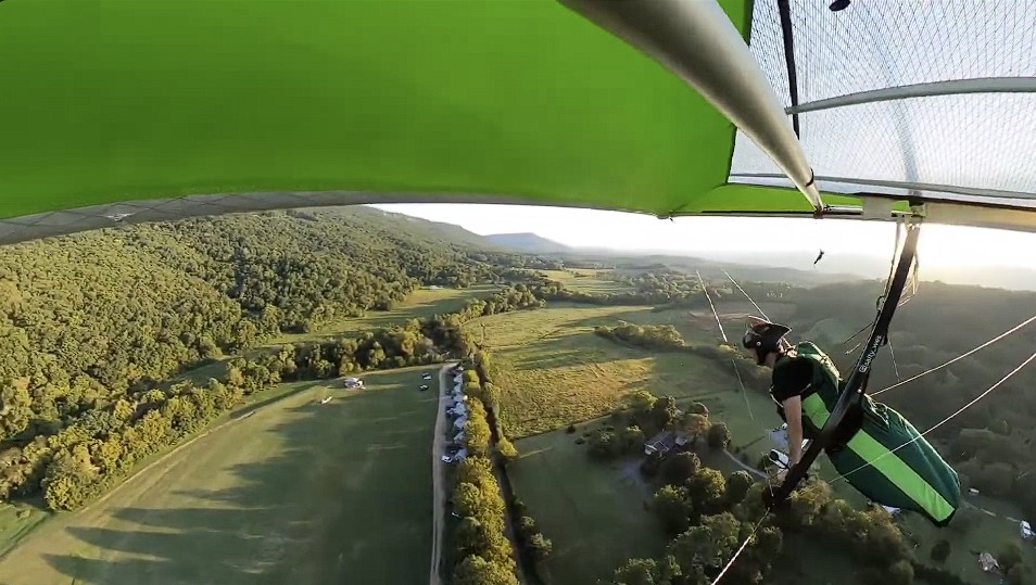 Hang glider soaring over mountain terrain